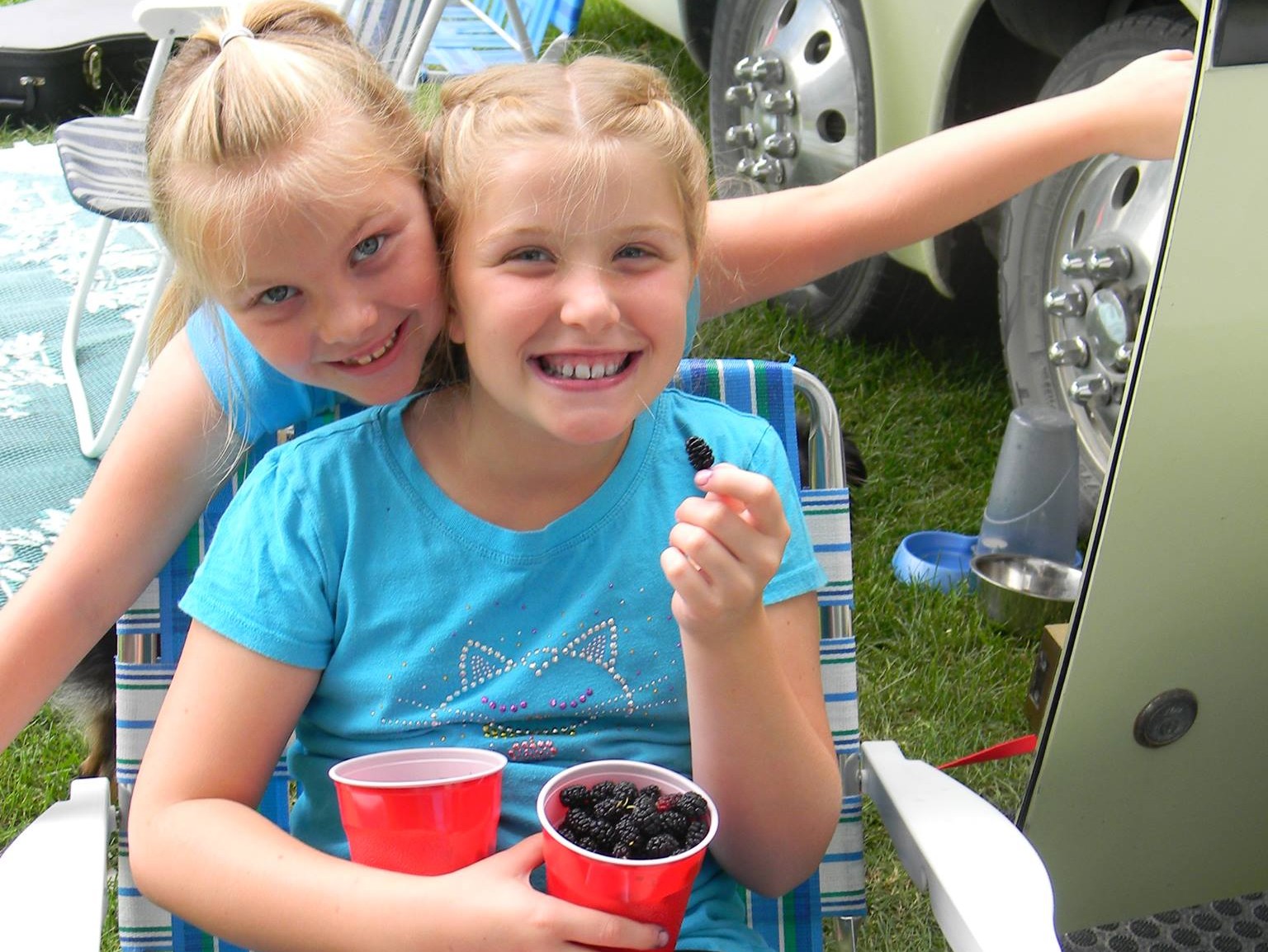 image of Kaitlyn Briggs with sister at Kalona festival eating mulberries